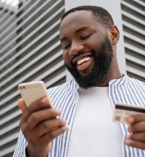 A smiling man looking at his mobile phone
